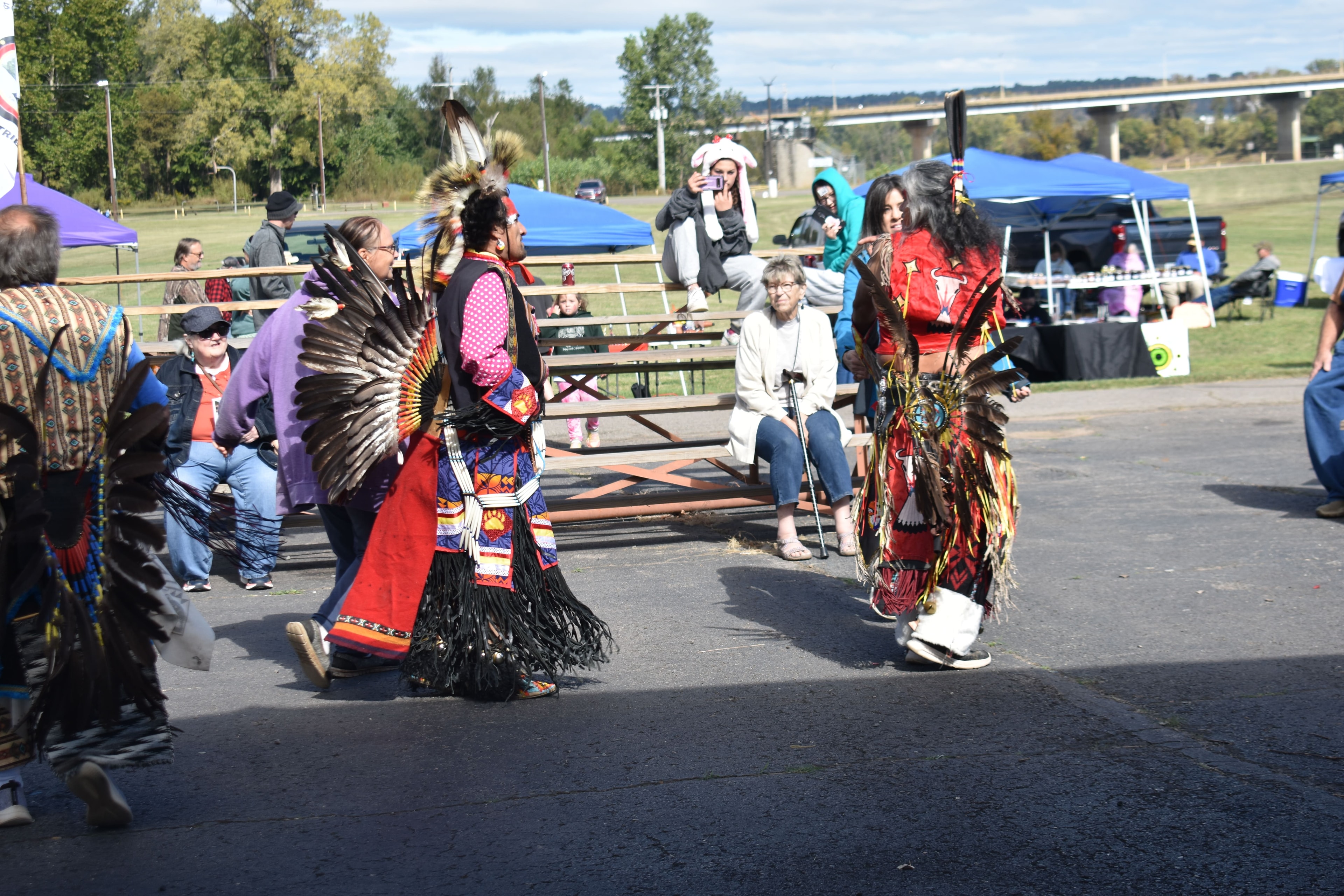 Cherokee dancers in colorful regalia performing at the festival