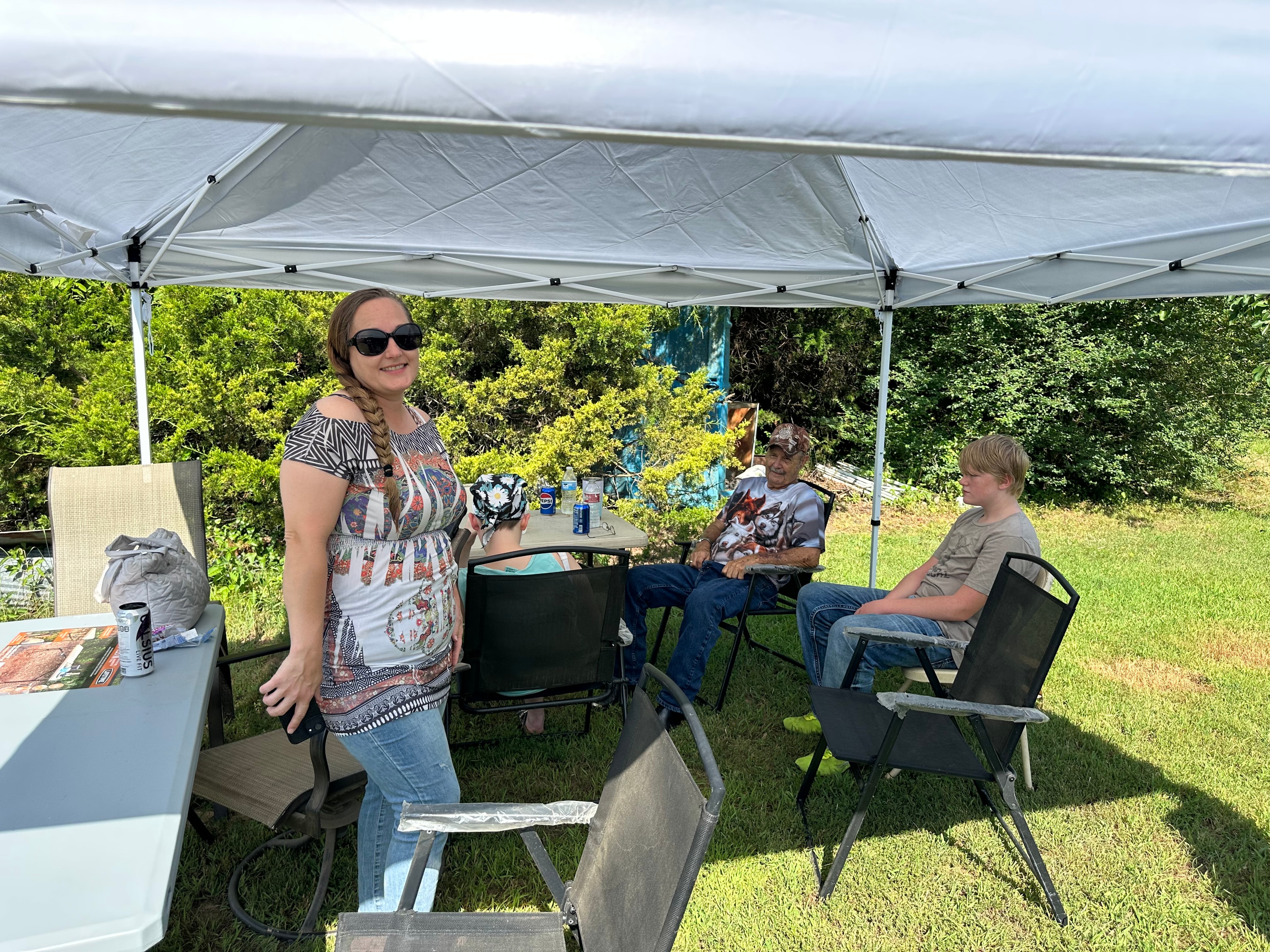 Tribal member smiling with family under the tent at Green Tree Ceremony July 11, 2026