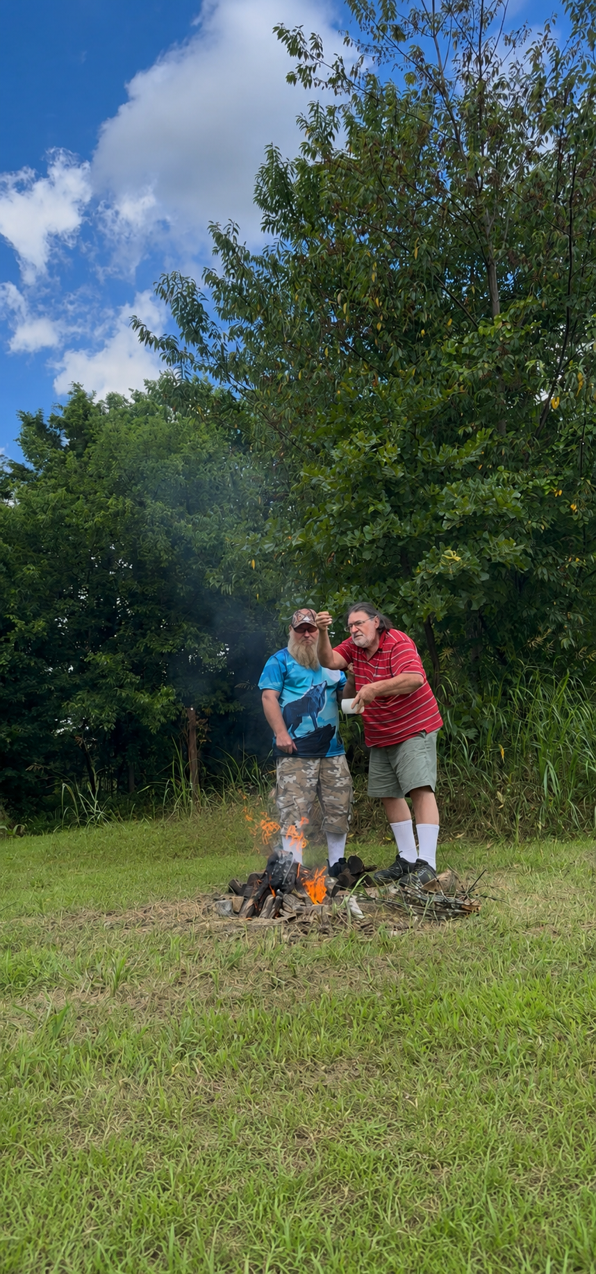 Two tribal members tending the sacred ceremonial fire at Green Corn Ceremony 2026