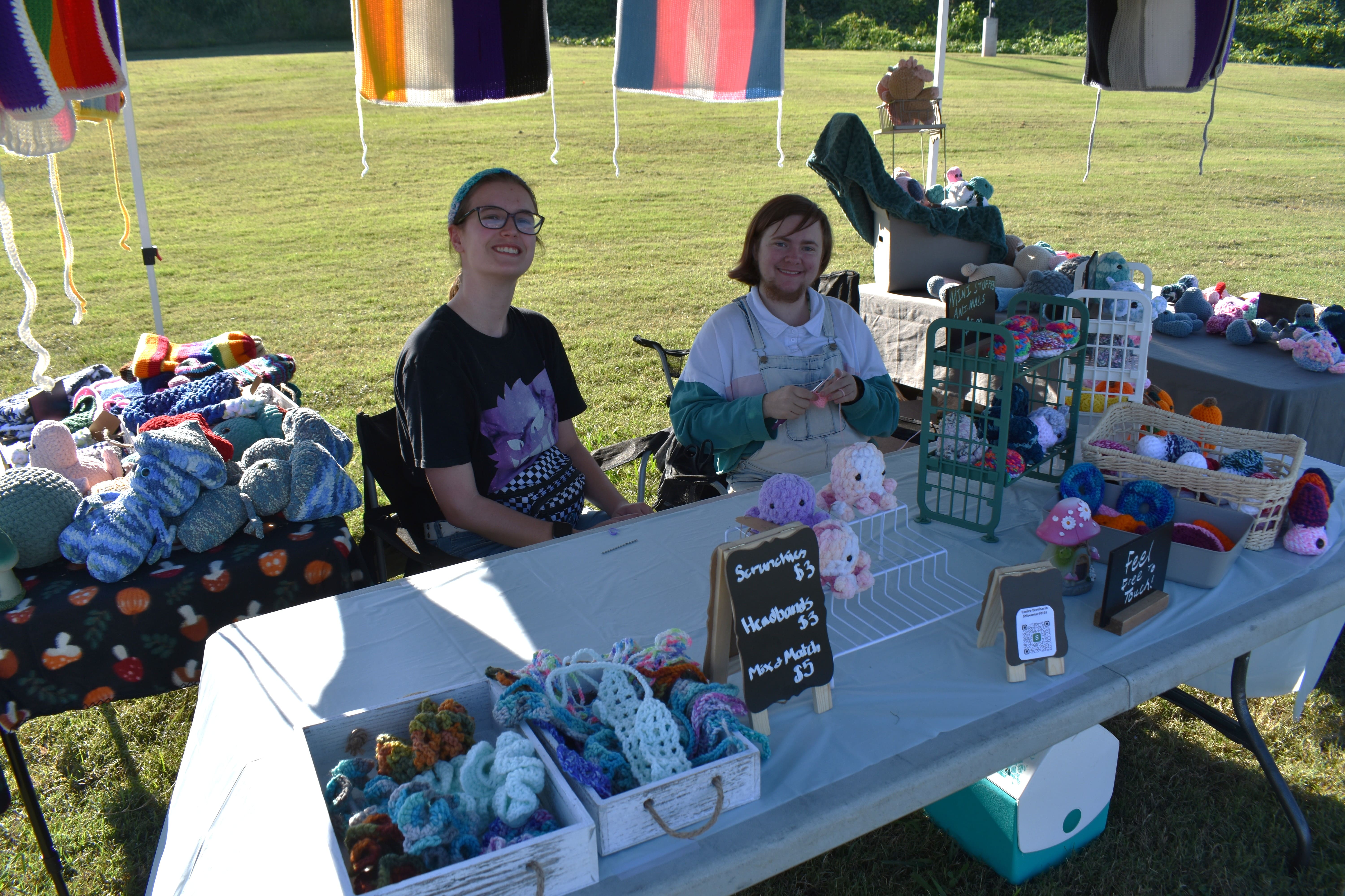 Two young vendors at a crocheted stuffed animals and accessories booth at October Festival 2025