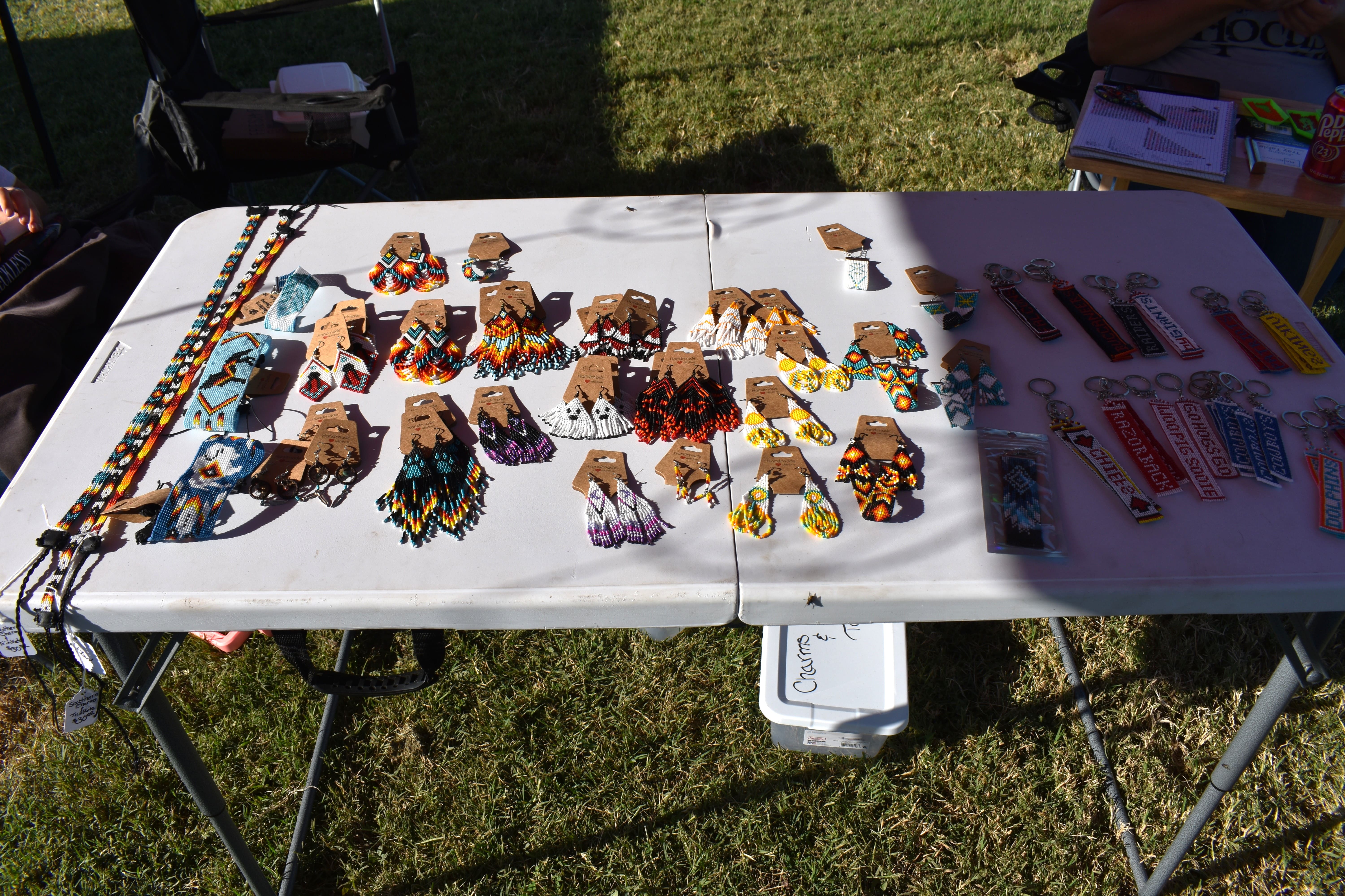 Table full of colorful Cherokee beadwork earrings and keychains at October Festival 2025